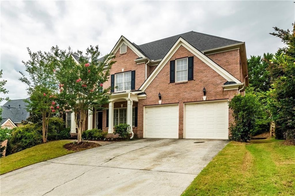 Traditional-style home with brick siding, a garage, driveway, a front lawn, and roof with shingles