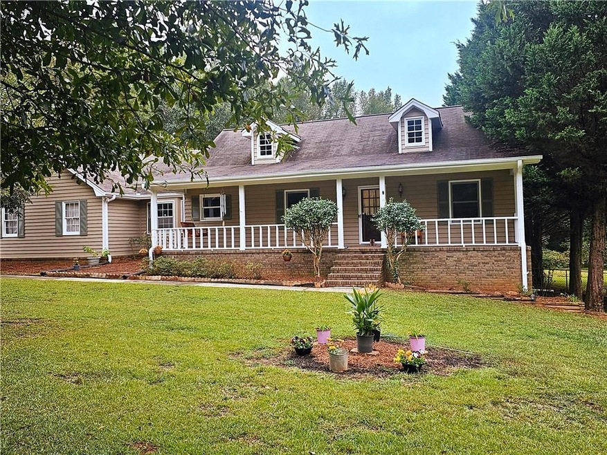 Cape cod-style house with a front yard and covered