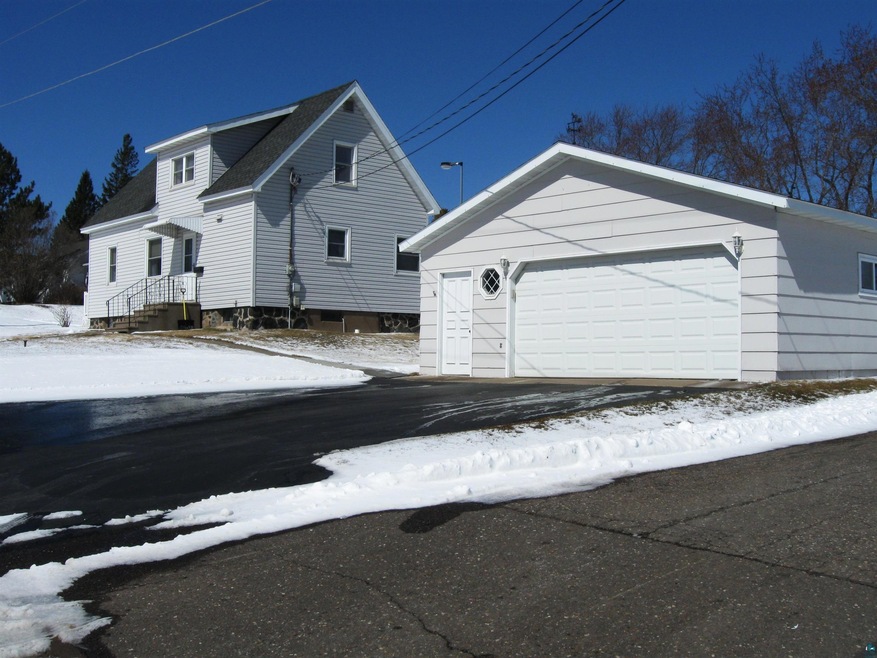 View of snowy exterior featuring a garage