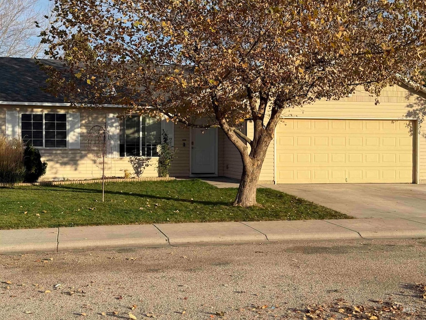 Obstructed view of property featuring driveway, a front yard, a shingled roof, and an attached garage