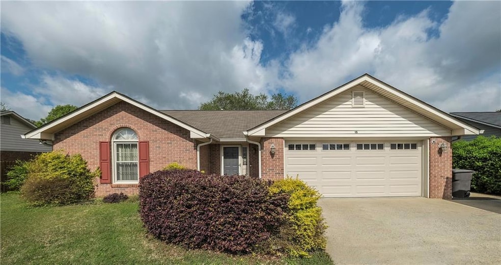 Single story home featuring a garage, brick siding