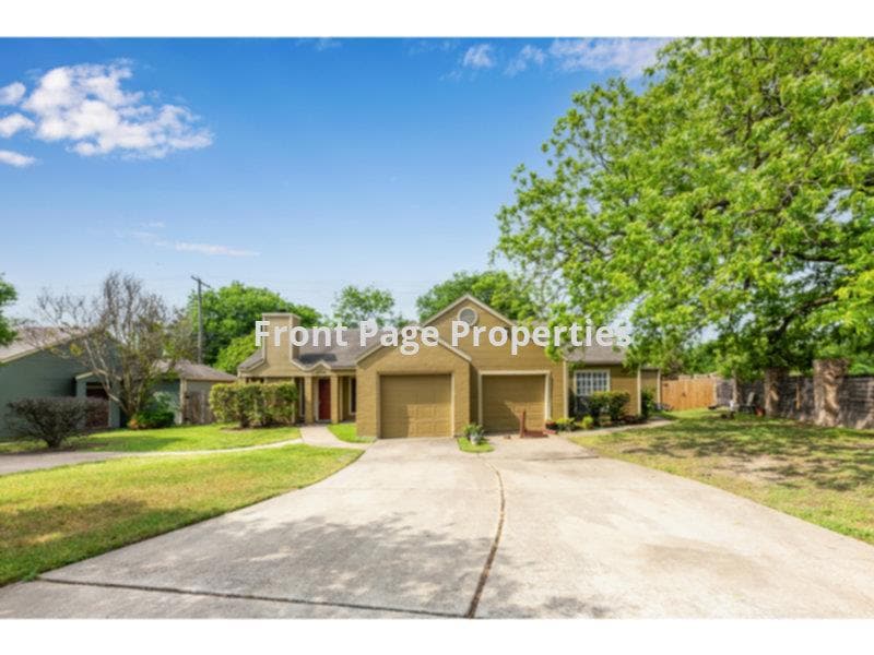 View of front of property featuring a garage, dri