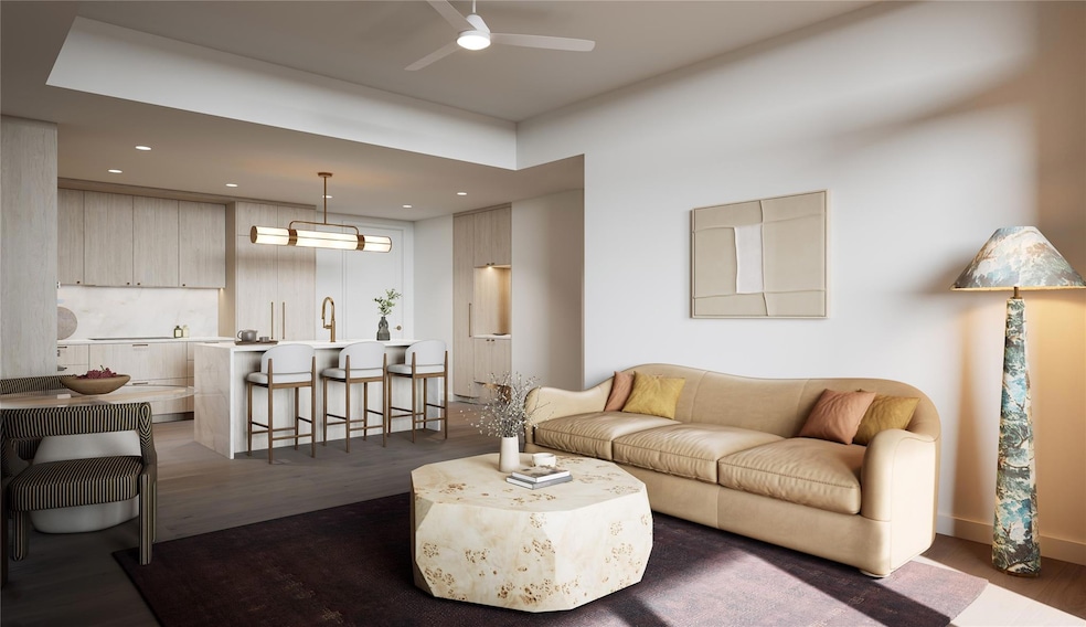 Open living area with kitchen and dining connection, featuring floor-to-ceiling windows, wood flooring, and recessed lighting. Natural tones and clean lines reflect the Tranquil Palette, creating a cohesive, light-filled interior.