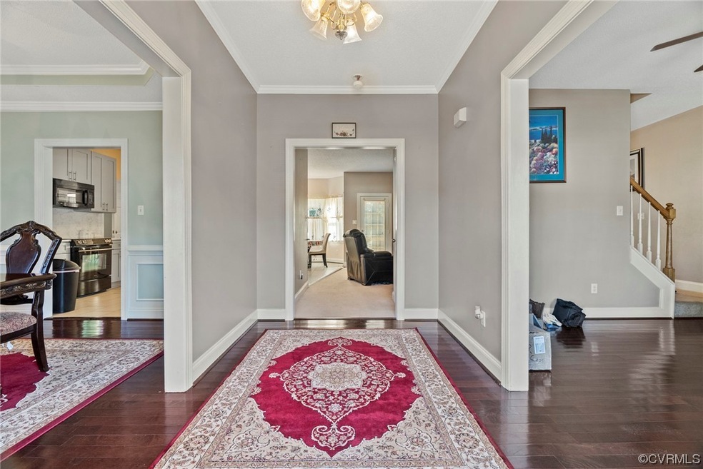 Foyer with a chandelier, ornamental molding, and d