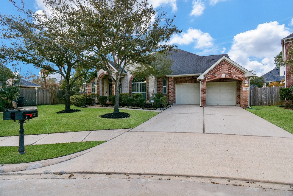This gorgeous, stately and meticulously maintained brick beauty is located at 13143 Oakwood Manor Drive, in the master planned Coles Crossing Community, Cypress, TX. This 1-1/2 story home occupies a 14,801 square-foot-lot, with 3,486 square-feet of interior living space. Seen here are the attached, dual-vehicle garage and wooden fencing on either side of the property. 3-4 bedrooms, 3 baths ready for immediate move-in!