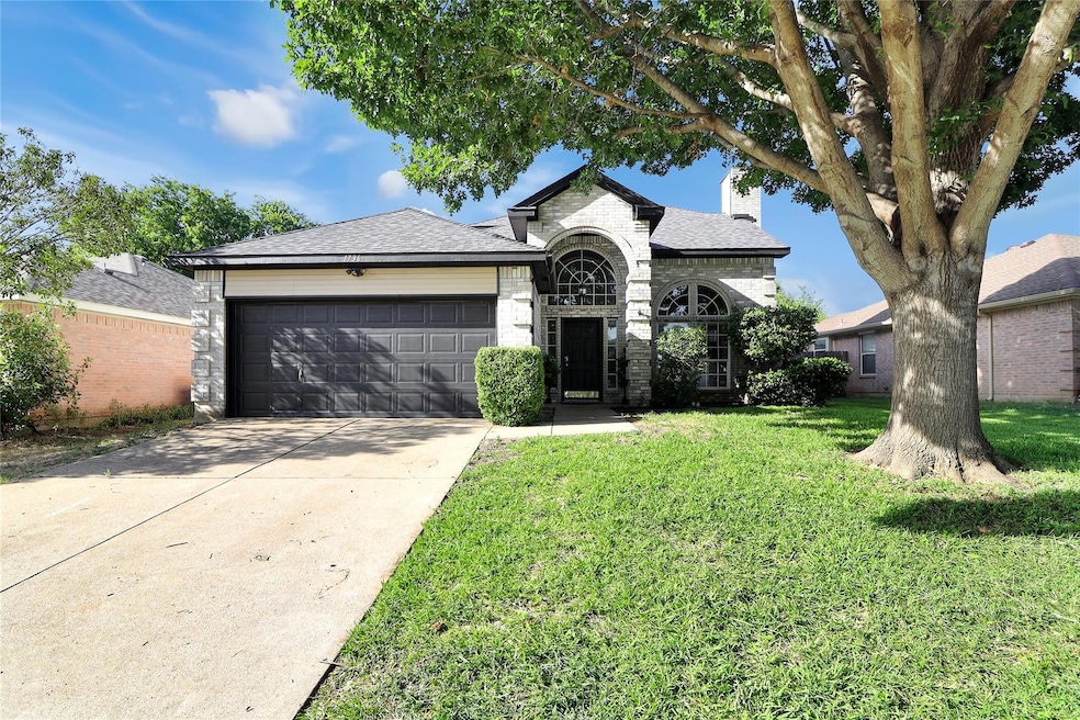 View of front of home with a garage and a front ya