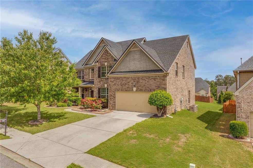 View of front of house with concrete driveway, bri