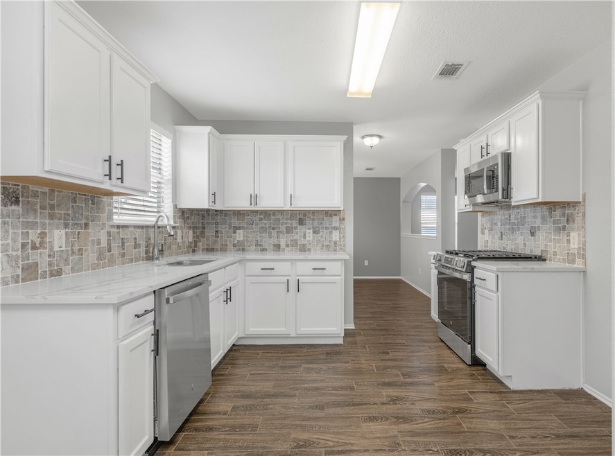 Kitchen featuring a sink, dark wood-style floors,