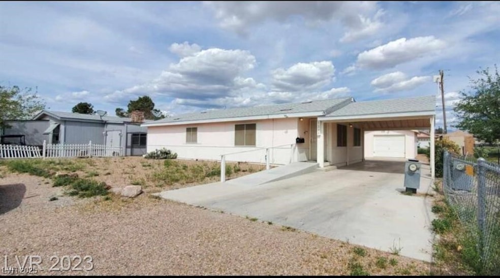 Single story home with a garage, driveway, and fen