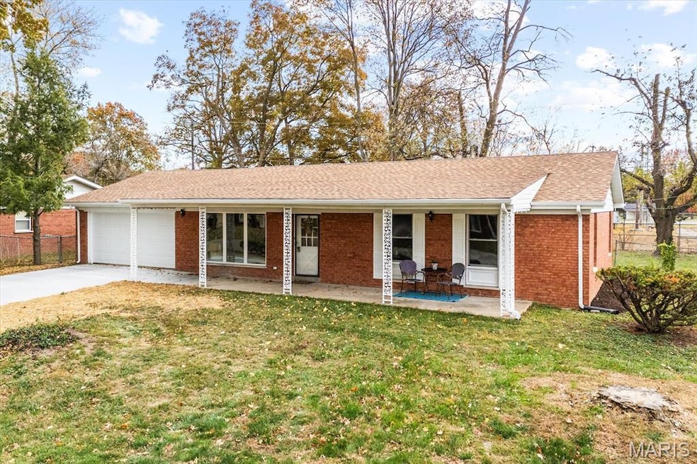 Ranch-style home with concrete driveway, covered porch, a shingled roof, brick siding, and a garage