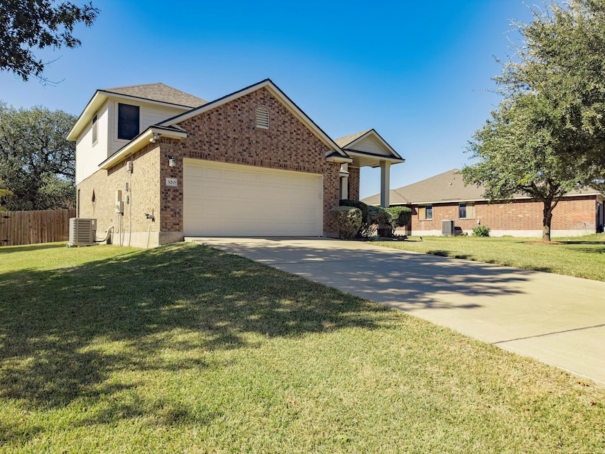 View of front of property featuring brick siding, driveway, and an attached garage