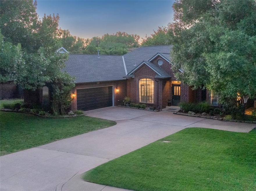 View of front facade with concrete driveway, a garage, a front yard, brick siding, and roof with shingles