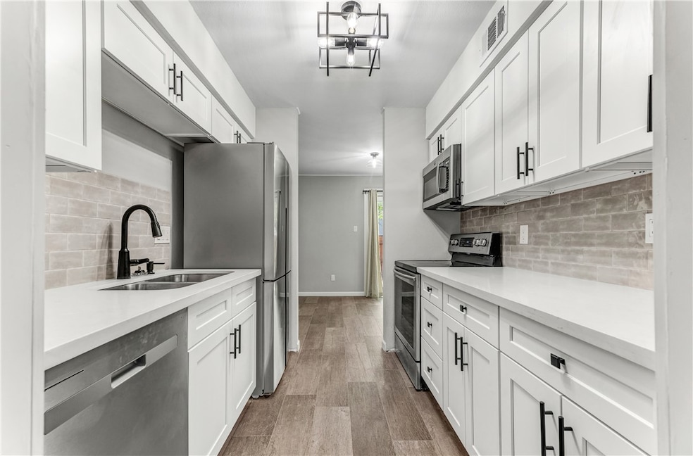 Kitchen with stainless steel appliances, backsplas