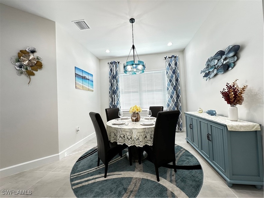 Dining area with a notable chandelier and light ti