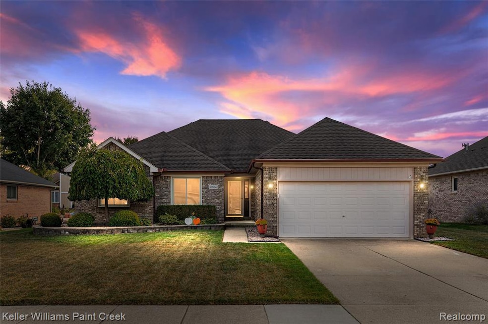 View of front of home with a lawn, brick siding, and a shingled roof