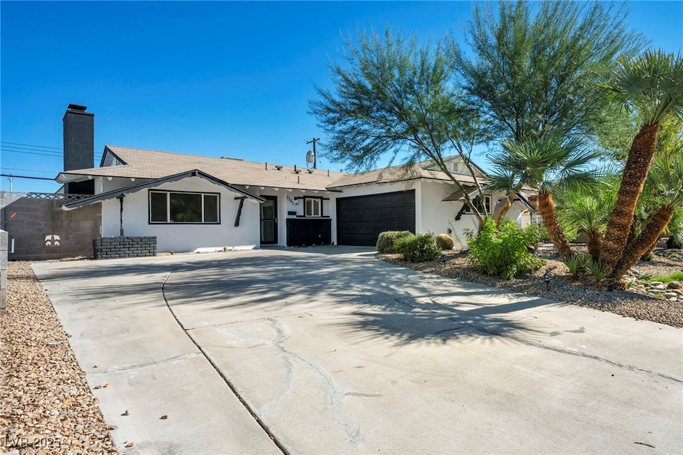 Single story home with stucco siding, driveway, an attached garage, and a chimney