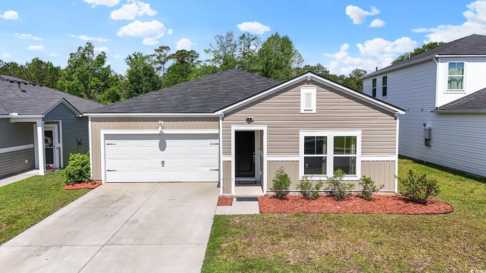 View of front of property with an attached garage, concrete driveway, and a front lawn
