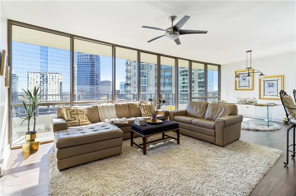Living room featuring ceiling fan, expansive windo