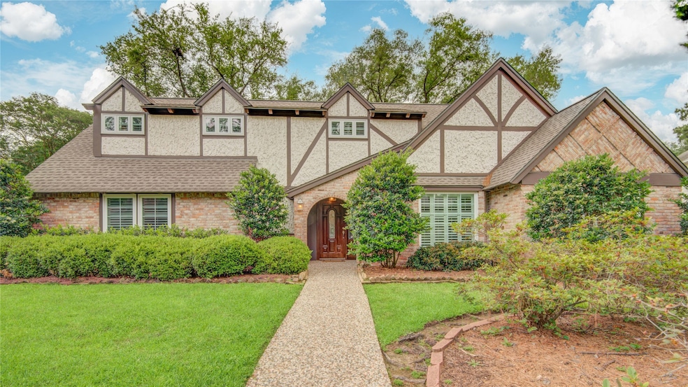 This charming Tudor-style home is surrounded by ma