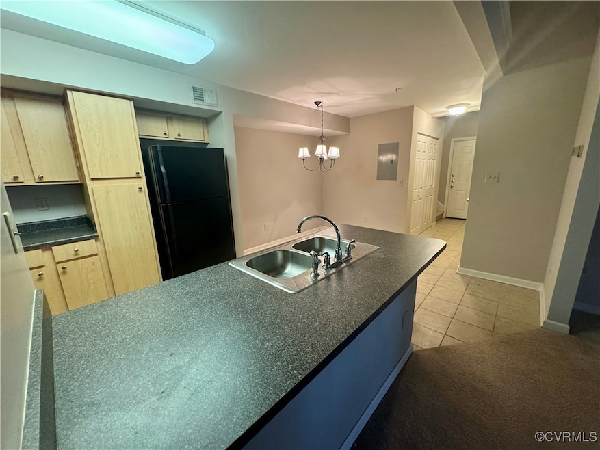 Kitchen featuring freestanding refrigerator, dark