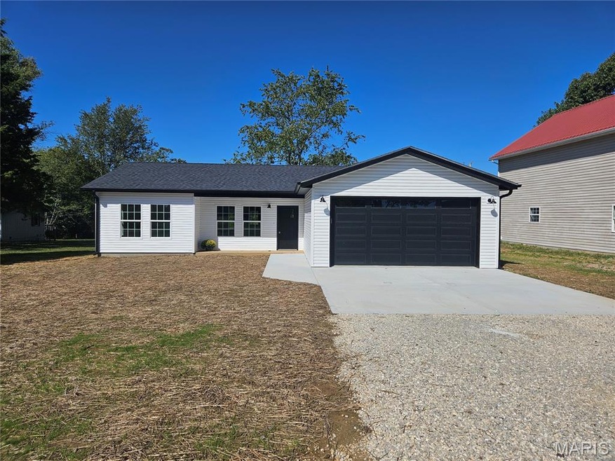 Ranch-style home featuring concrete driveway and a garage