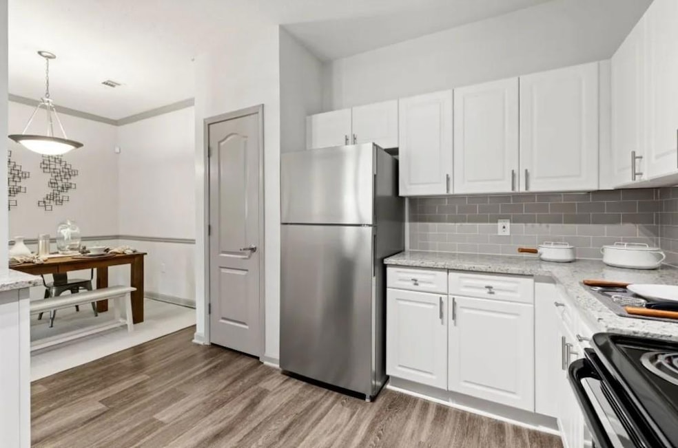 Kitchen featuring white cabinetry, range with elec
