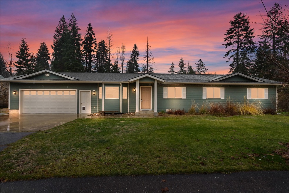 Single story home with a yard and a garage
