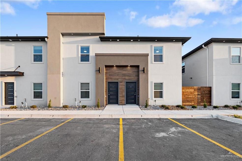View of building exterior with fence and uncovered parking