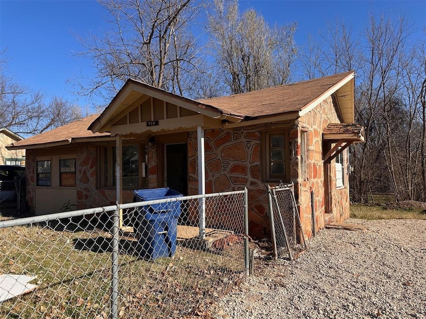 View of front of home featuring fence, roof with s