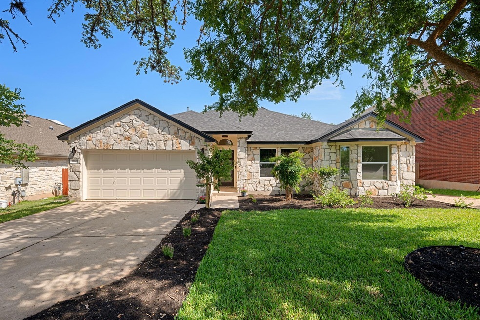 View of front of home with stone siding, a garage