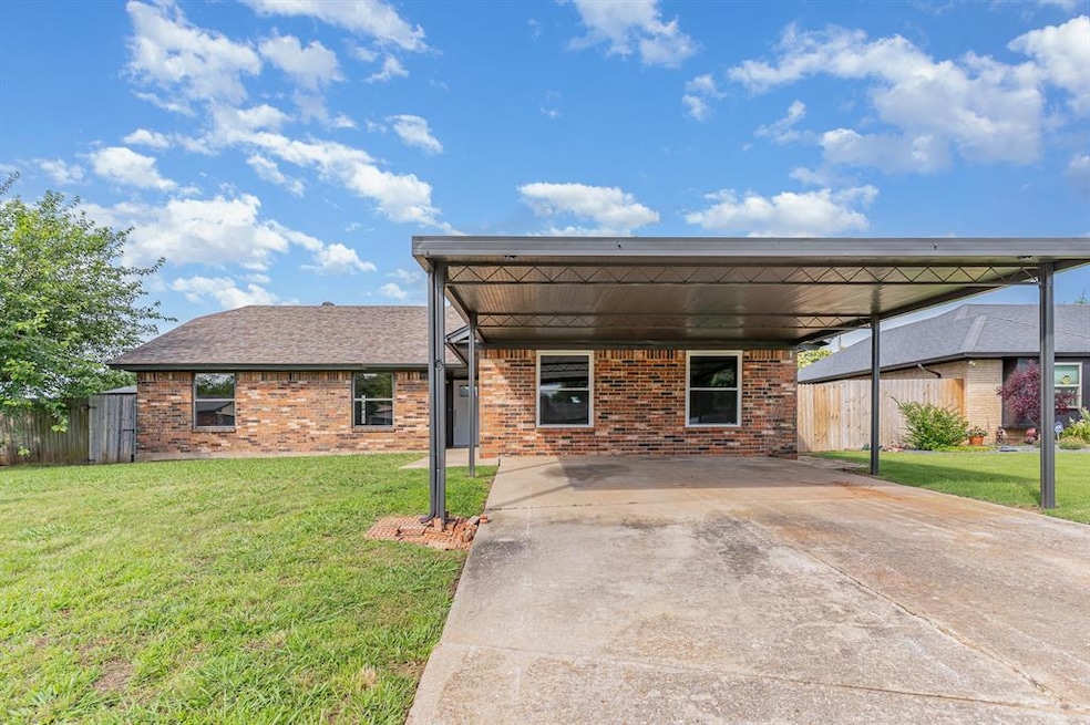 View of front of house featuring brick siding, concrete driveway, and a carport