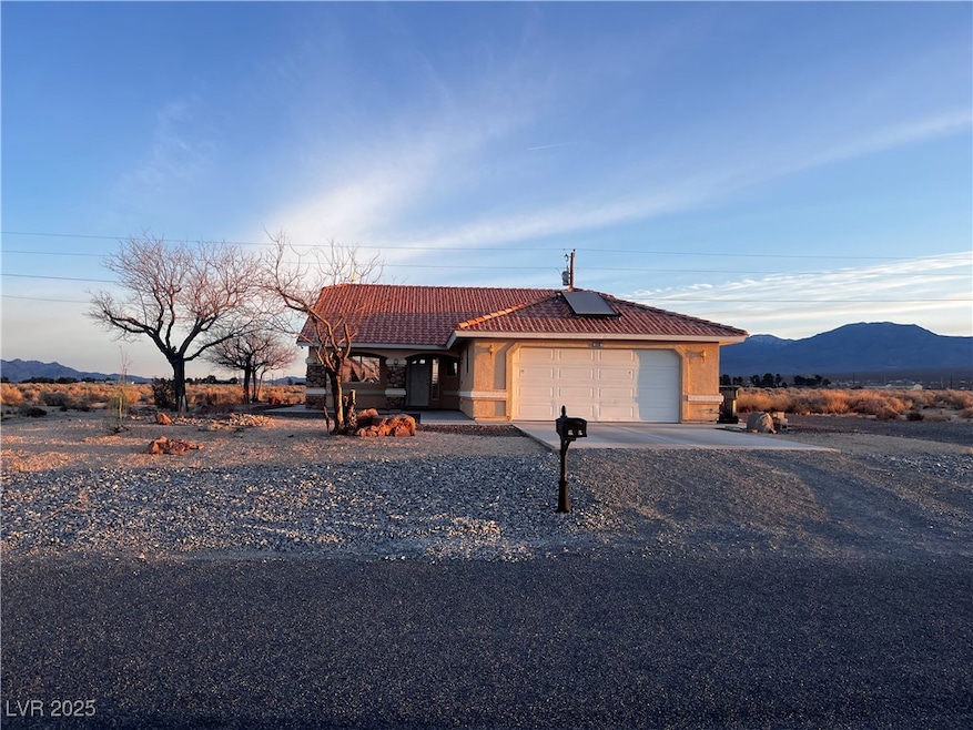 View of front of home with a mountain view, a gara