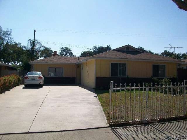 Front of the home with a long driveway and gate