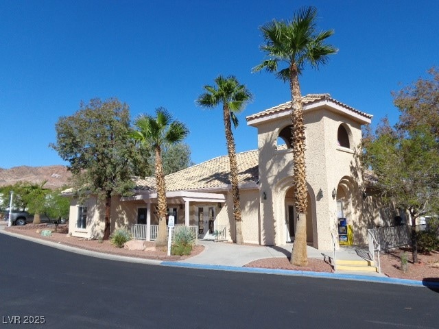View of front facade with stucco siding and a tile