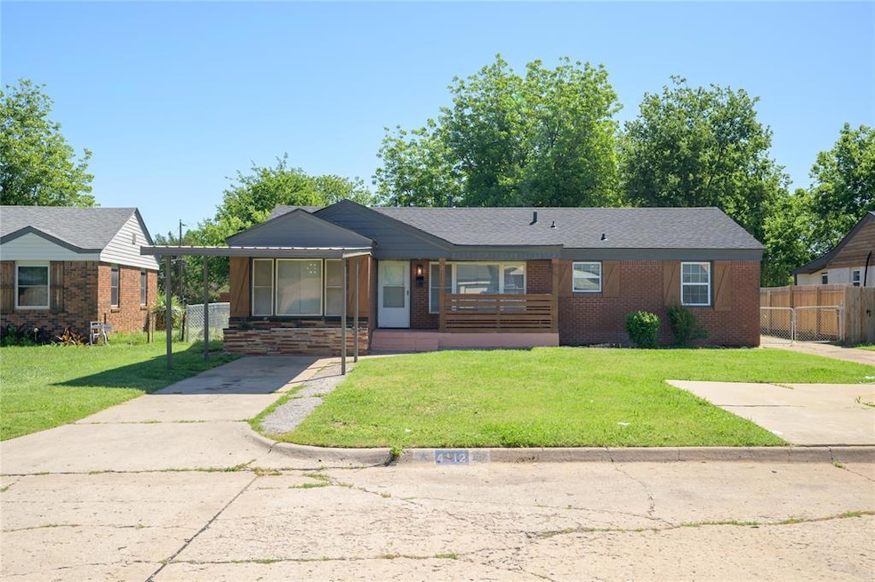 View of front of house with a porch, concrete driveway, an attached carport, and brick siding