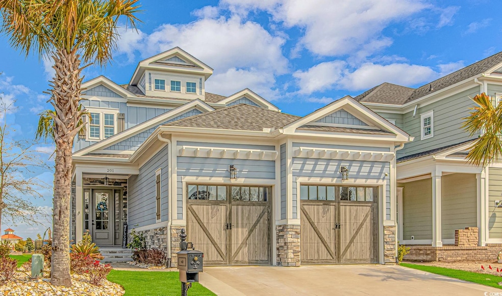 Craftsman-style home with roof with shingles, driveway, an attached garage, and board and batten siding