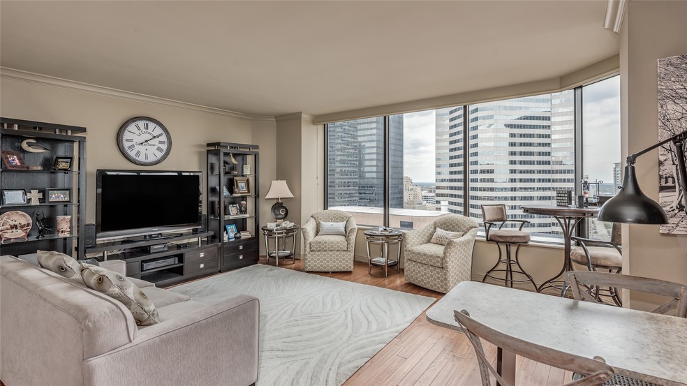 View of the spacious living space in this 26th floor corner unit overlooking Downtown Houston and Discovery Green Park!