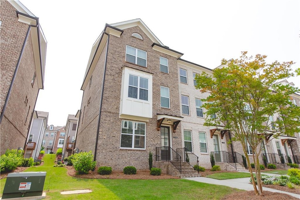 Townhome / multi-family property featuring brick siding, a residential view, and a front yard