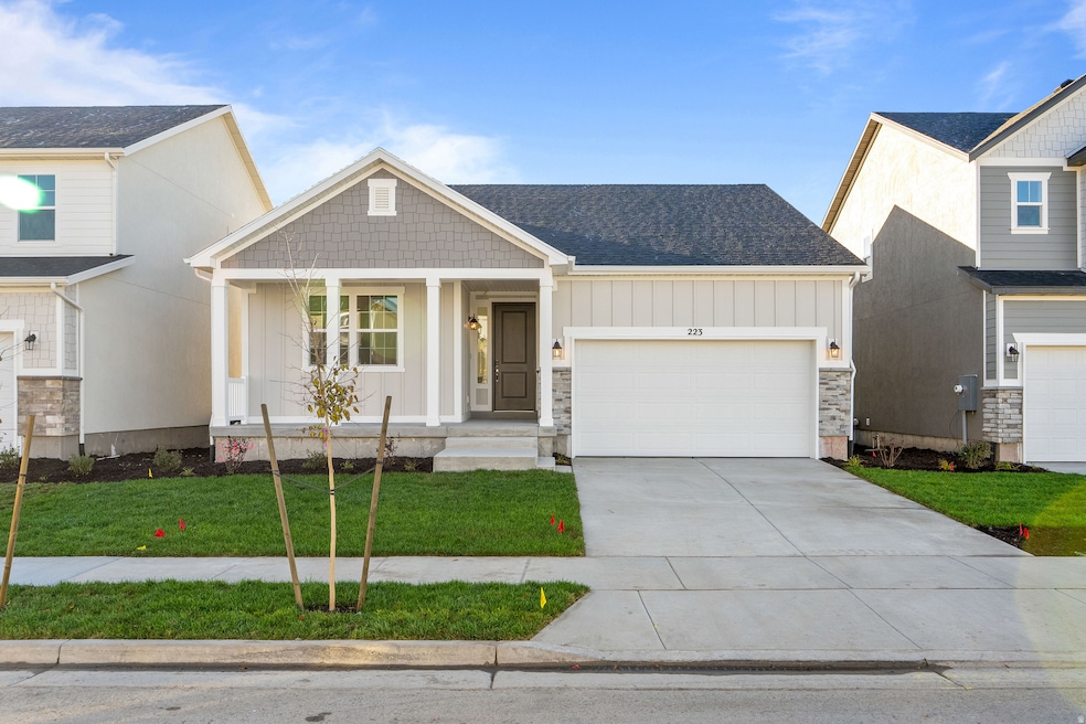 Craftsman house featuring board and batten siding, a porch, concrete driveway, a front yard, and roof with shingles