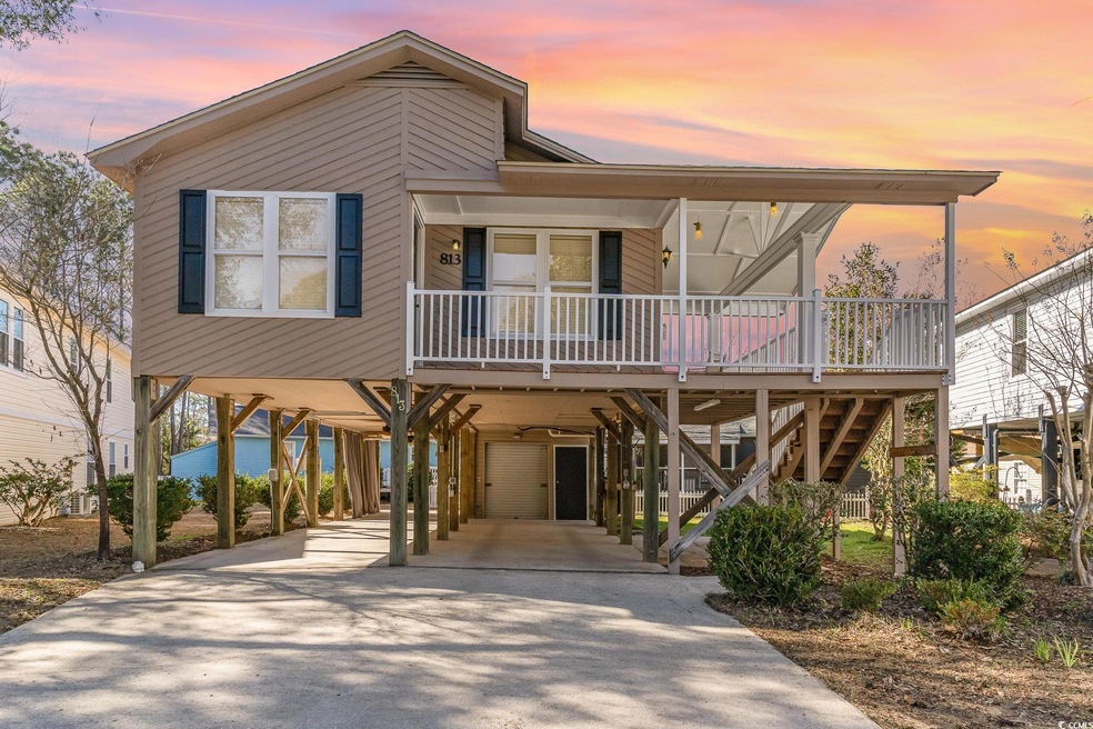 Beach home featuring covered porch, stairway, a ca