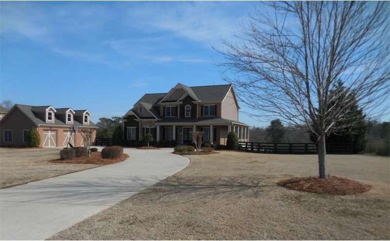 Front of home wi.th round about drive and oversized 3 car garage