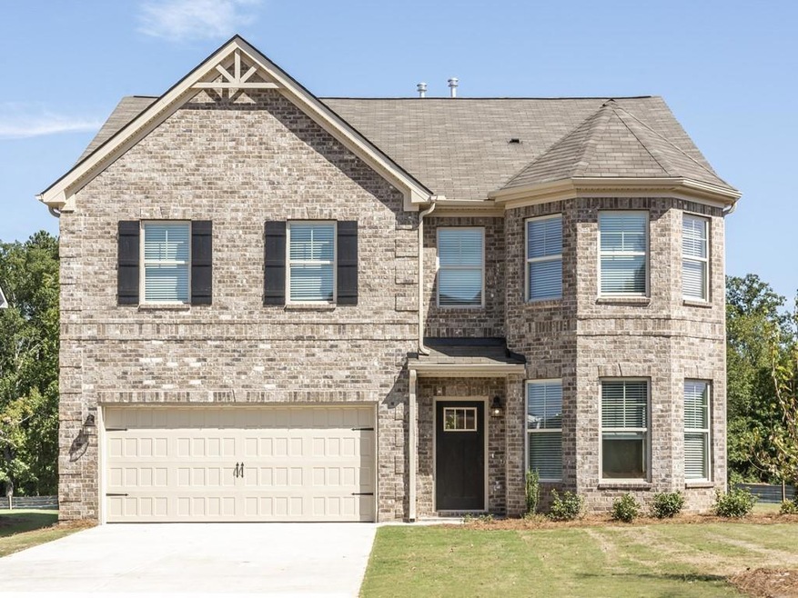 View of front of house with a front yard and a gar