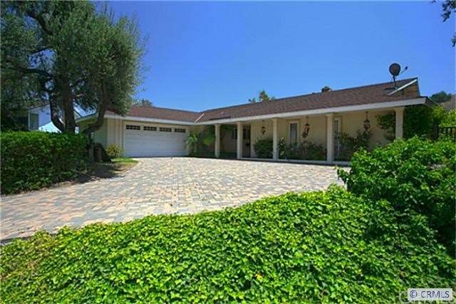 Curbside view of ranch style home with extra long 