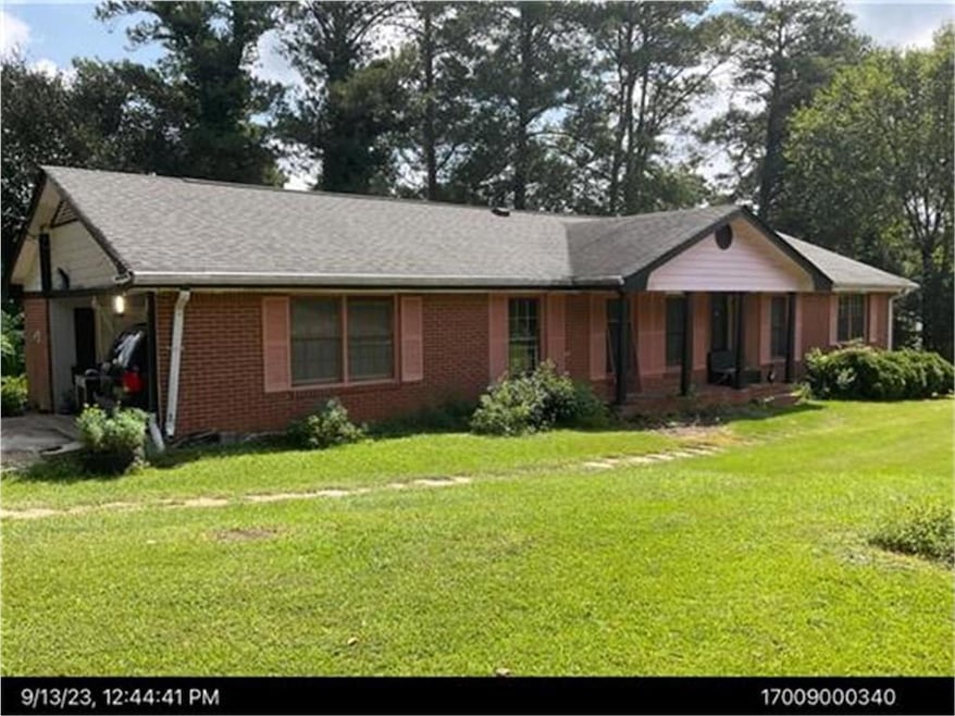 Single story home featuring brick siding and a front lawn