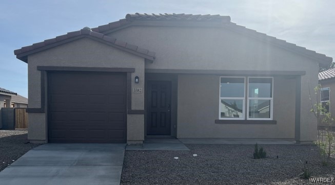 Ranch-style house featuring driveway, stucco sidin