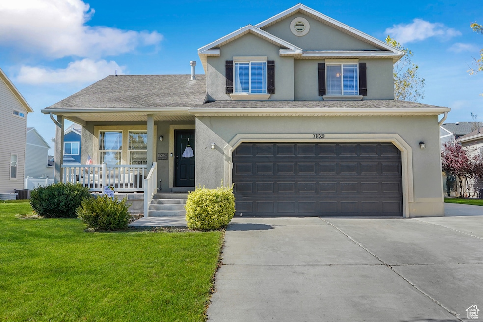 View of front of home featuring covered porch, stucco siding, roof with shingles, a front yard, and an attached garage