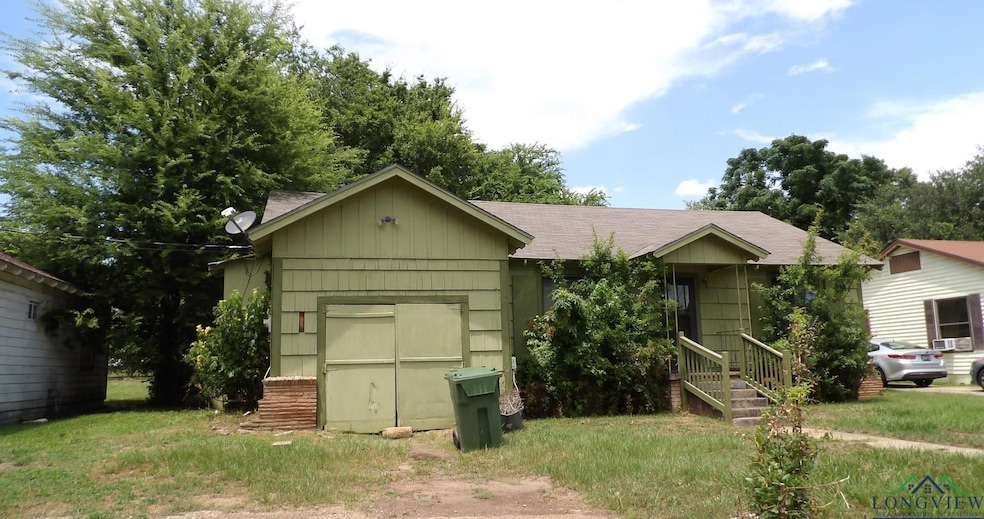 View of front facade with a shingled roof and a garage