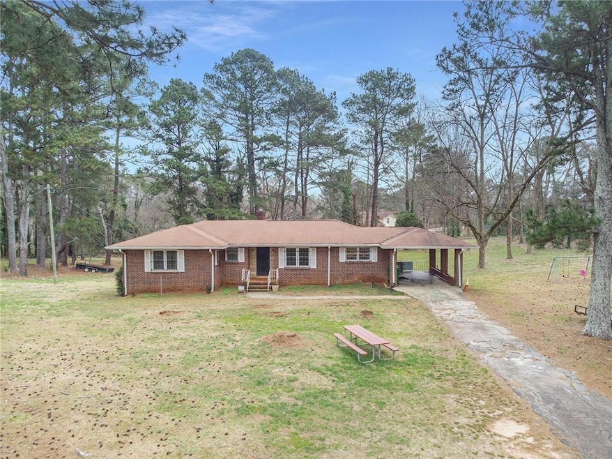 Ranch-style home with a front lawn and a carport