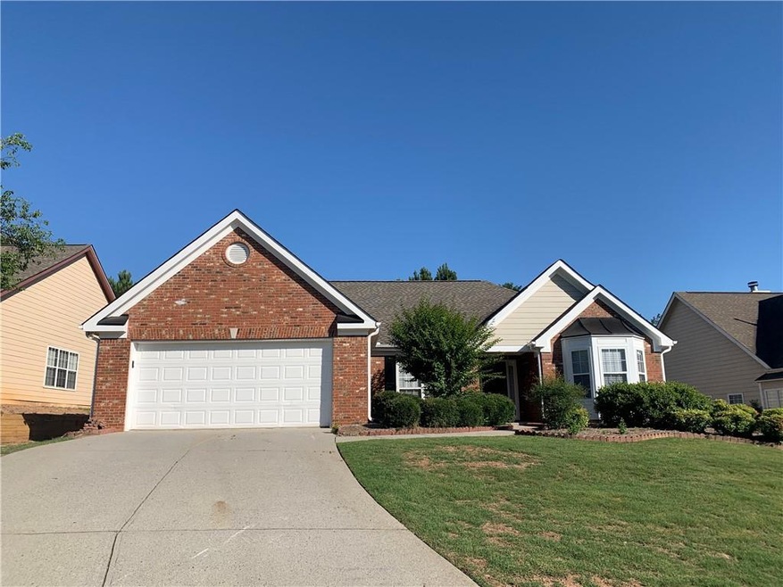 Single story home featuring concrete driveway, a f