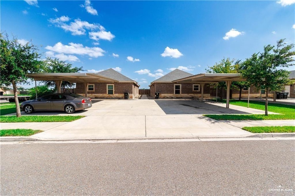 View of front of property featuring covered and uncovered parking and brick siding